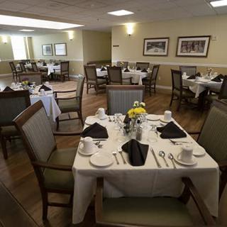 A neatly arranged dining room with tables set for a formal meal.