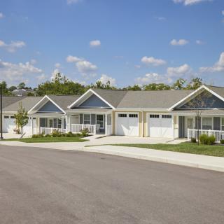A row of suburban houses under a clear blue sky.