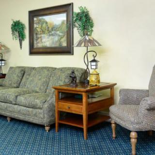 A cozy living room with a sofa, armchair, side table, and decorative elements.