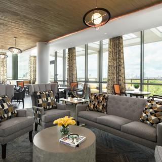 A modern lounge area with comfortable seating and large windows letting in natural light.