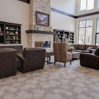 A spacious and elegantly designed living room with comfortable seating and a central fireplace.