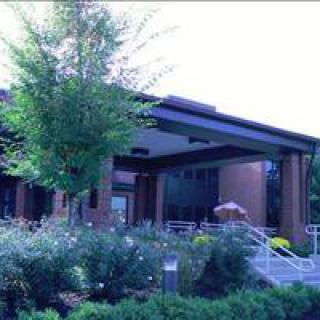 A modern building surrounded by lush greenery and a well-maintained garden.