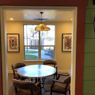 A cozy dining area with a round table and comfortable chairs, illuminated by a stylish pendant light.