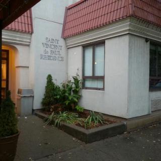 A view of a building's exterior featuring a landscaped garden and window.