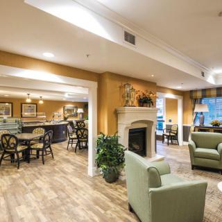 A cozy and well-designed living room with adjacent dining area, featuring a fireplace, comfortable seating, and warm lighting.