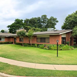 A picturesque view of a modern residential house surrounded by a lush green lawn.