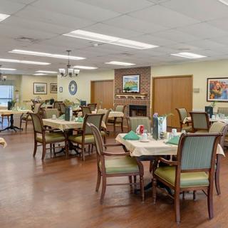 An inviting dining room with neatly arranged tables and chairs, featuring warm lighting and tasteful decor.