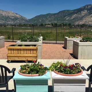 A scenic patio with planters and a mountain view on a sunny day.