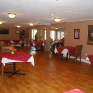 A spacious dining area with neatly arranged tables and chairs, featuring warm lighting and inviting decor.