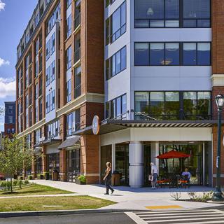 A modern mixed-use building with retail space on the ground floor and residential apartments above.