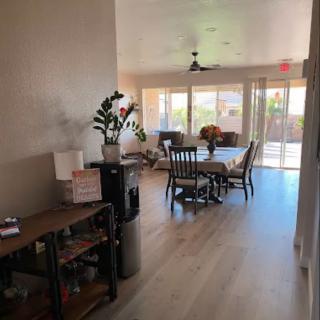 A cozy home interior with a dining area and living room, featuring wooden floors and natural light.