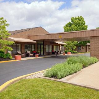 A building with a covered entrance and landscaped surroundings.