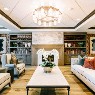 A stylish living room featuring elegant furniture, a chandelier, and built-in bookshelves.