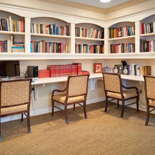 A cozy library with bookshelves, desks, and chairs for reading or study.