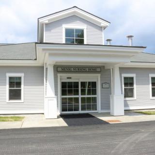 A small white building with a prominent entrance and large windows.