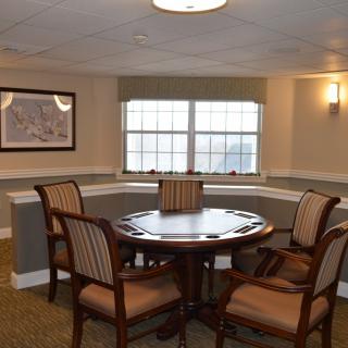 A cozy dining area with a round wooden table surrounded by four chairs, set near a window with natural light.