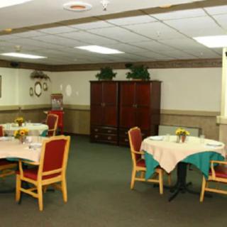 A neatly arranged dining area with tables and chairs, featuring decorative elements.