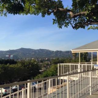 A scenic view of mountains and trees from a balcony with a railing.