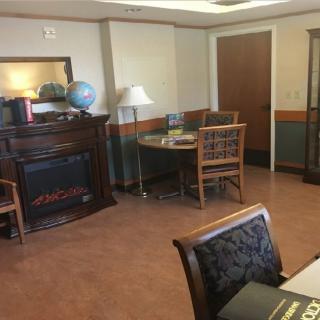 A cozy office space with a fireplace, globe, and wooden furniture.