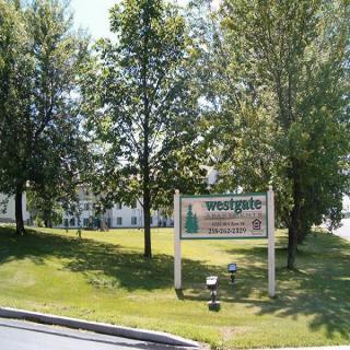 A park area with a sign reading 'Westside' surrounded by trees and grass.