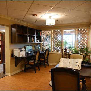 A cozy office space with desks, computers, and a large window allowing natural light.