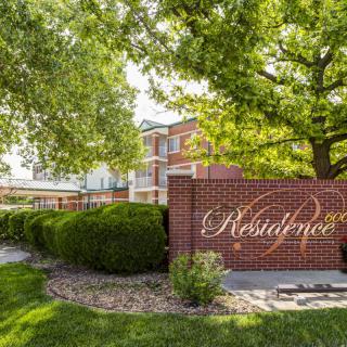 Entrance sign for a residential or commercial building with surrounding greenery.
