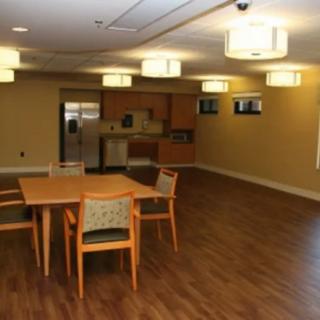 An empty dining area with a kitchen in the background.