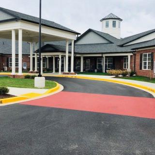 A modern building with a covered entrance and circular driveway.