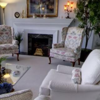 A cozy living room with floral armchairs and a fireplace.
