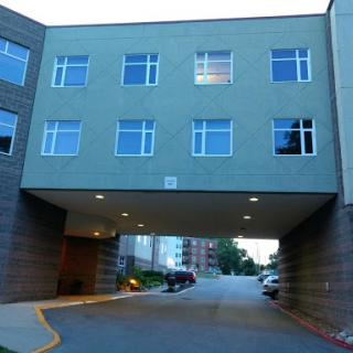 A modern building featuring a parking area beneath it.