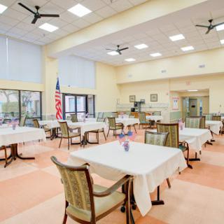 A spacious and well-lit dining area featuring neatly arranged tables and chairs, perfect for casual dining.