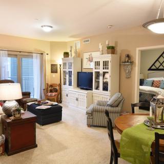 A cozy living room with a comfortable seating area, white entertainment unit, and an adjacent dining table.
