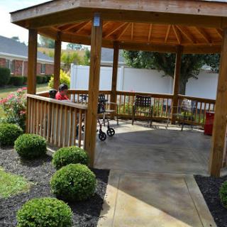 A cozy gazebo surrounded by well-maintained shrubs, providing a peaceful outdoor space for gathering.
