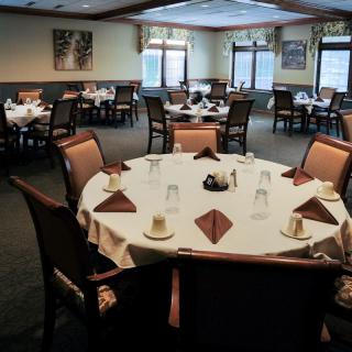 A well-arranged dining area with round tables set for guests in a restaurant.