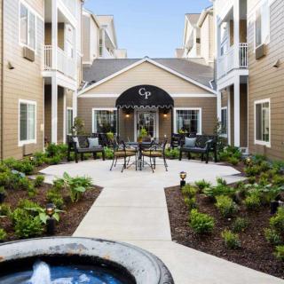 A modern apartment complex featuring a landscaped courtyard with outdoor seating.