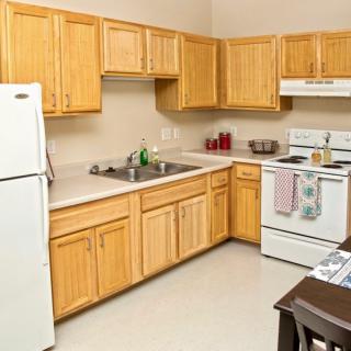 A modern kitchen with wooden cabinets and standard appliances.