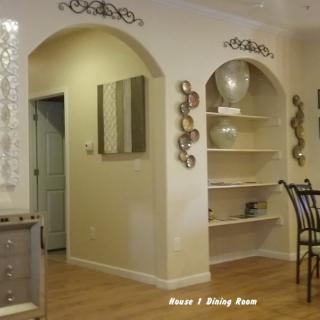 A cozy dining area featuring an arched entryway, decorative wall art, and built-in shelves.