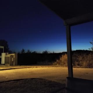 A serene night landscape transitioning into dusk, illuminated softly by ambient light.