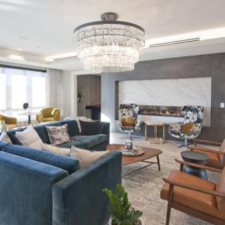 A modern living room with elegant furnishings and a large chandelier.