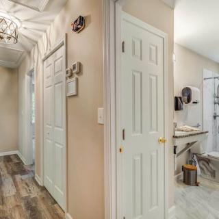 A well-lit hallway with multiple doors leading to a bathroom and laundry area.