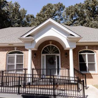 A single-story brick house with a front ramp and columns.