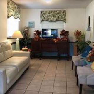 A cozy living room with a sofa, chairs, and a television surrounded by decorative elements.
