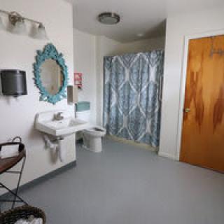 A spacious bathroom featuring a sink, decorative mirror, and shower curtain.