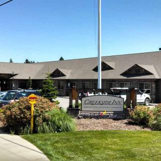 A commercial building with a parking lot and landscaped surroundings.