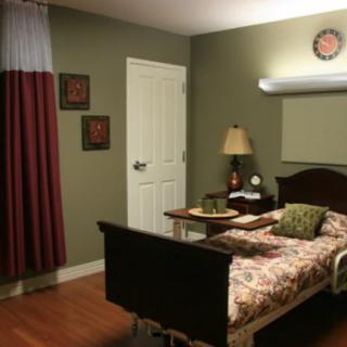 A cozy bedroom with a single bed, bedside lamp, and warm decor.