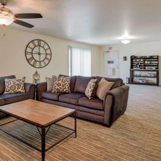 A cozy living room with a large wall clock and comfortable seating area.