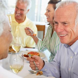 A group of people enjoying a meal and conversation at a restaurant.