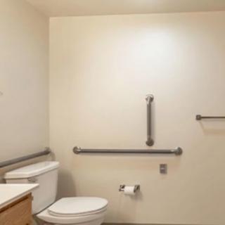An accessible bathroom with grab bars and a toilet.