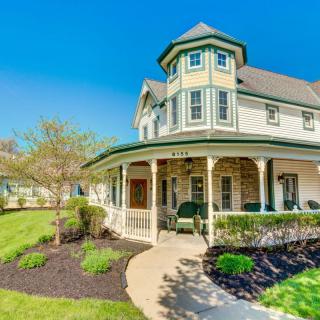 A beautiful Victorian-style house with a wrap-around porch and well-maintained garden.