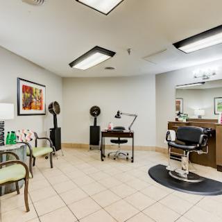 A modern barber shop interior with a stylist station and waiting area.